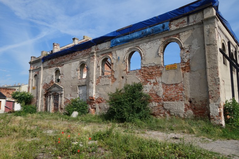 What's left of the Żychlin synagogue. Note the windows used to extend much father down, and the more recent doorway (now blocked) added when the building was used as a warehouse. The weedy area in the foreground used to be a fenced garden.